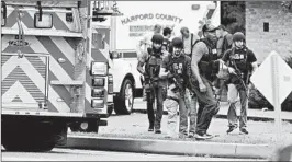  ?? MATT BUTTON/BALTIMORE SUN ?? A group of ATF police makes its way to the shooting scene in northeaste­rn Maryland.