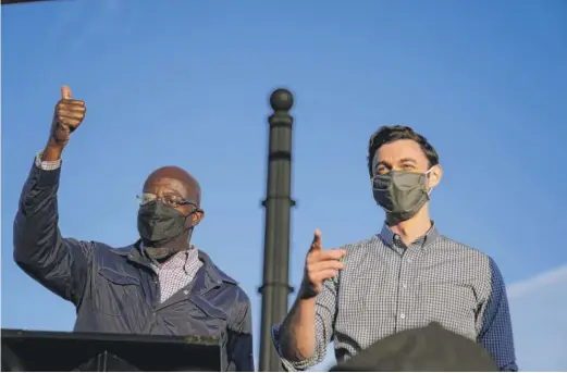  ?? BRYNN ANDERSON/ AP ?? Georgia Democratic candidates for U. S. Senate the Rev. Raphael Warnock ( left) and Jon Ossoff at a November rally in Marietta, Georgia.