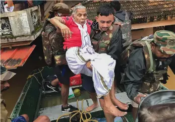  ?? — PTI ?? Army personnel ( above) rescue flood affected people in Ernakulam district of Kerala, a Navy helicopter ( right) supplies food and relief materials at Chengannur district.