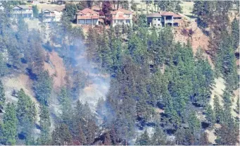  ?? JONATHAN HAYWARD/THE CANADIAN PRESS ?? Smoke and fire retardant is seen along a neighbourh­ood in Lake Country, B.C., Sunday. Officials say they are beginning the process of notifying those who have lost homes in the out-of-control wildfires.