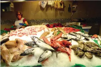  ??  ?? Sur les étals des poissonnie­rs de la Boqueria, merlans, congres, morues et compagnie, fraîchemen­t pêchés, observent les clients d’un oeil éberlué.