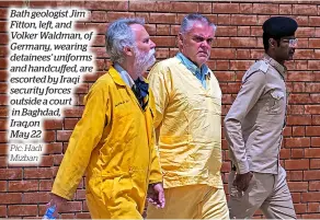  ?? Pic: Hadi Mizban ?? Bath geologist Jim Fitton, left, and Volker Waldman, of Germany, wearing detainees’ uniforms and handcuffed, are escorted by Iraqi security forces outside a court
in Baghdad, Iraq,on May 22