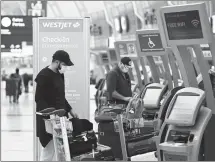  ?? Canadian Press photo/Nathan Denette ?? People check in at WestJet at Pearson Internatio­nal airport during the COVID-19 pandemic in Toronto on Oct. 14.