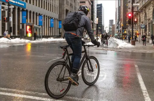  ?? DAVE SIDAWAY ?? Cyclists wait for a green light at Peel St. on the de Maisonneuv­e Blvd. bike path, a high-traffic cycling route, last week.