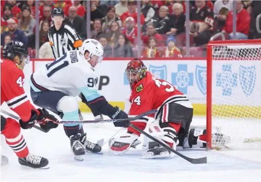  ?? GETTY IMAGES ?? Daniel Sprong scores the first of the Kraken’s six first-period goals. Hawks starting goalie Petr Mrazek yielded four goals on five shots before being pulled.