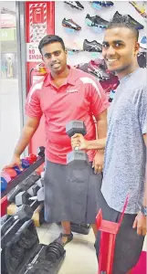  ?? Picture: ATU RASEA ?? Sportsworl­d in Nakasi staff member Shanhil Prasad left, with customer Sanjesh Prasad with a dumbbell at the fitness corner.