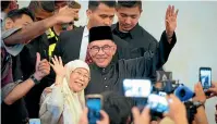  ?? AP ?? Malaysia’s newly appointed Prime Minister Anwar Ibrahim and his wife Wan Azizah wave as they arrive at a gathering in Kuala Lumpur.