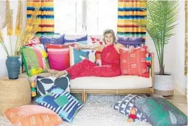  ?? SPACECRAFT­ING ?? Designer Lucy Penfield at home with her colorful collection of pillows for Missio Home.