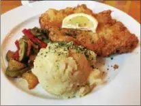  ?? PHOTOS BY MARK MESZOROS — THE NEWS-HERALD ?? The nicely breaded French Orly Schnitzel at Hansa Brewery comes with homefries that are more like heavy mashed potatoes than what you typically think of as homefries and vegetables.