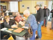  ?? Ben Lambert / Hearst Connecticu­t Media ?? New Hartford residents came out to vote in the municipal election Tuesday. Left, poll workers help voters at town hall.