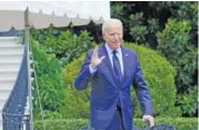  ?? AP PHOTO/SUSAN WALSH ?? President Joe Biden tries to hear questions shouted by reporters Friday as he heads to Marine One on the South Lawn of the White House in Washington to spend the weekend at Camp David.