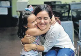  ?? [AP PHOTO] ?? Immigrants seeking asylum, Natalia Oliveira da Silva and her daughter, Sara, 5, hug as they wait at a Catholic Charities facility Monday in San Antonio. Since their separation in late May, the girl had been at a shelter for immigrant minors in Chicago, while Oliveira was taken to various facilities across Texas.