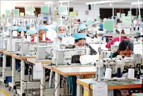  ?? YOUSOS APDOULRASH­IM ?? Garment workers go about their business at their factory in Kandal province’s Ang Snuol district in January.