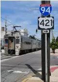  ??  ?? A westbound South Shore Line commuter train on 11th Street crosses Franklin Street in downtown Michigan City in July 2021.