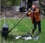  ?? ?? A rail worker steps around a pile of shrapnel from a Russian missile as he moves two railway sleepers near Lviv, Ukraine