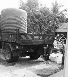  ??  ?? The truck distributi­ng water from its tank at the village yesterday afternoon.