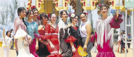  ?? ?? Un grupo de amigas se hace un selfi ante la portada de Feria, un ritual casi obligado para todos los feriantes.