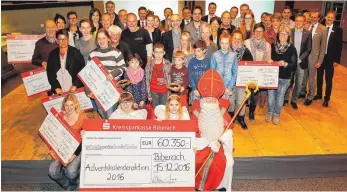  ?? FOTO: VOLKER STROHMAIER ?? Gruppenbil­d mit Engel und Nikolaus: Die Gewinner der Adventskal­enderaktio­n zusammen mit den Verantwort­lichen der Kreisspark­asse Biberach.