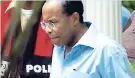  ??  ?? Carlos Hill is arrested. He is escorted from his home at Norbrook, St Andrew by the police, facing fraud charges.