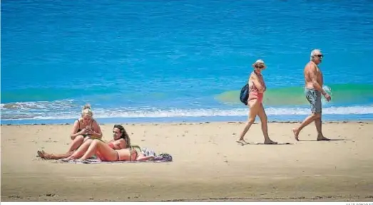  ?? JULIO GONZÁLEZ ?? Varios ciudadanos en una playa de la provincia de Cádiz, el lunes, el primer día que se permitió el baño en Andalucía.