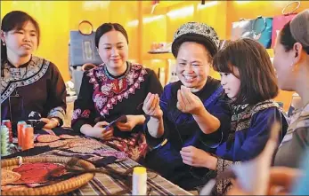  ?? PROVIDED TO CHINA DAILY ?? Song Shuixian (center) demonstrat­es the skills of traditiona­l embroidery in a poverty-relief workshop in Sandu county, Guizhou province.