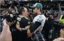  ?? BILL FEIG — THE ASSOCIATED PRESS ?? New Orleans quarterbac­k Drew Brees, left, and Eagles QB Nick Foles share a moment after the Saints rallied for a 20-14 victory Sunday.