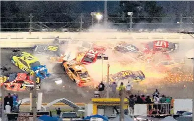  ?? JOE BURBANK/ORLANDO SENTINEL ?? A crash takes out much of the field during the final stage of Sunday’s race in Daytona Beach. There were three crashes and two redflag stoppages in the last 10 laps. Hamlin eventually coasted to the win ahead of Joe Gibbs Racing teammate Kyle Busch.