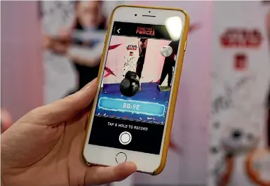  ?? GETTY ?? Fans can interact with characters such as Star Wars’ BB-9E using an AR app on their smartphone.