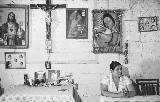  ?? Photos by Jerry Lara / Staff photograph­ers ?? Maria de los Dolores Romero Medina, 36, sits in a room surrounded by an altar dedicated to her late son, Jose Eugenio Hernandez Romero, 14, in Nuevo Laredo, Mexico.