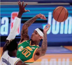  ?? MARK J. TERRILL/AP ?? Utah Jazz guard Jordan Clarkson, right, passes the ball as Los Angeles Lakers guard Dennis Schroder defends during the first half Saturday in Los Angeles.