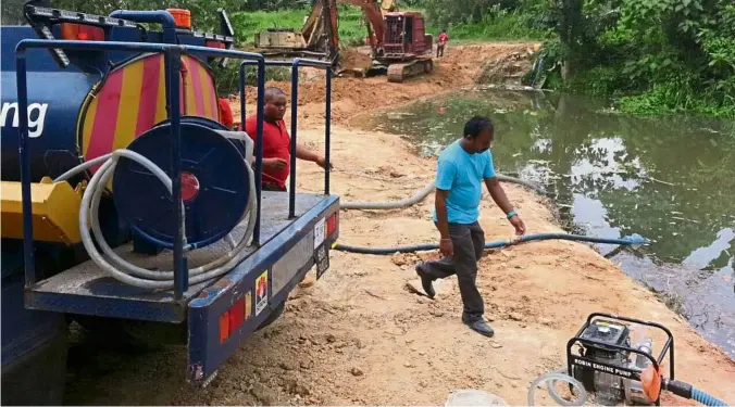  ?? — Sarban Singh/ The Star ?? Damage control Workers pumping out contaminat­ed water from Sg Buah.