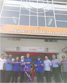  ??  ?? Awang Tengah cuts the ribbon to mark the official opening of Anjung Usahawan Lawas in Merapok. He is flanked by his wife Datuk Dayang Morliah Awang Daud and Henry, while Naroden is seen at front, third left.