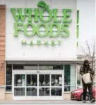 ?? PAT NABONG/SUN-TIMES FILE ?? A shopper walks out of Whole Foods Market in Englewood on the day in April the company announced the store would be closing.