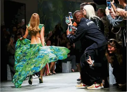  ?? — reuters ?? Lopez once again caused a buzz, but this time on the runway by walking in a redesigned version of her iconic Grammy awards green Versace dress.