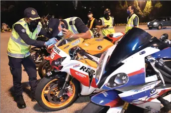  ?? — Bernama photo ?? RTD officers inspect some of the motorcycle­s that were detained during the operation.