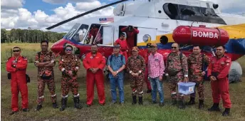  ?? ?? Gerawat (fifth left) with the Marudi Bomba team before boarding their helicopter to his village in Bario.