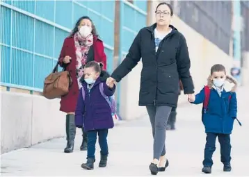  ?? SETH WENIG/AP ?? Young children wearing face masks are taken to a school on March 7 in New York.