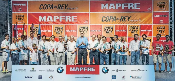  ??  ?? El Rey, con los armadores y patrones de los barcos vencedores en las diez clases de la Copa del Rey Mapfre 2017. Rafael Carbonell, segundo por la izquierda,ha ganado su quinta Copa, mientras Pedro Campos, el segundo con trofeo a la izquierda de don Felipe, obtiene su décima Copa.El podio de los ganadores.