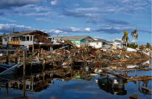  ?? REBECCA BLACKWELL/ASSOCIATED PRESS/FILE 2022 ?? Cars and debris from washed away homes lined a canal in Fort Myers Beach, Fla. last October, one week after Hurricane Ian. The storm was the single most damaging event in the country.