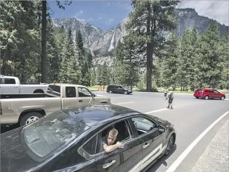  ?? Brian van der Brug Los Angeles Times ?? RANGERS direct traffic in congested Yosemite Valley. “Traffic jams are choking one of our most cherished natural wonders,” said a local environmen­tal activist. “Maybe it’s time for a federal court judge to decide whether Yosemite is violating its own...