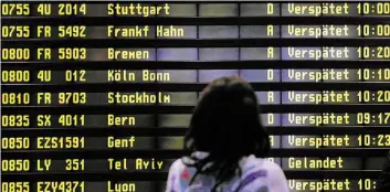  ?? DPA-BILD: HANSCHKG ?? Gine Frau steht auf dem Flughafen Berlin-Schönefeld vor einer Anzeigetaf­el, auf der verspätete Flüge aufgeliste­t werden.
