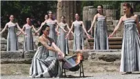  ?? (AFP) ?? Greek actress Mary Mina, playing the role of the High Priestess, lights the torch during the rehearsal of the flame lighting ceremony for the Paris 2024 Olympics Games at the ancient temple of Hera on the Olympia archaeolog­ical site, birthplace of the ancient Olympics in southern Greece, yesterday.