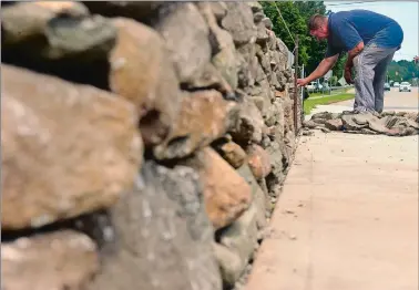  ?? SARAH GORDON/THE DAY ?? Randall Bumgarner, with Oaks Stone Wall Constructi­on Company in Norwich, works on building a drystone retaining wall on Wednesday at a home on Briggs Street in New London.