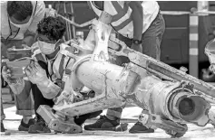  ?? — AFP photo ?? File photo shows Lion Air investigat­ors examining part of the landing gear of the ill-fated Lion Air flight JT 610 at the port in northern Jakarta.