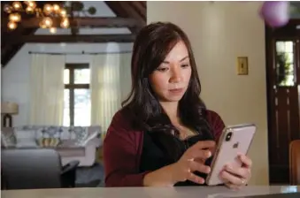  ?? AP PHOTO/RANDALL BENTON ?? Emergency room physician, Dr. Anna Nguyen uses her smartphone to communicat­e with a remote patient from her Sacramento, Calif., home in 2019.