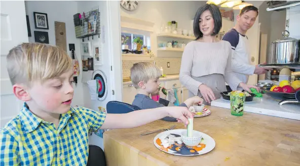  ?? PHOTOS: GERRY KAHRMANN/PNG ?? Jacqueline and Bryce Tupper put out food prepared by Eat Your Cake as young sons Sebastian, left, and Nolan get anxious for dinner. ‘It’s a really busy time, which is why Eat Your Cake saves my bacon,’ says Jacqueline, who runs her own business.