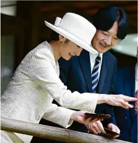  ?? Fabio Braga/Folhapress ?? O príncipe Akishino e a princesa Kiko alimentam carpas no Pavilhão Japonês, do parque Ibirapuera; eles foram saudados por crianças no local, onde também plantaram uma árvore