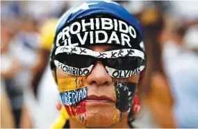  ??  ?? AN OPPOSITION supporter participat­es in a candleligh­t rally against President Nicolas Maduro in Caracas, Venezuela, on May 17.