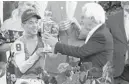  ?? JEFF ROBERSON/AP ?? Trainer Bob Baffert hands the winner’s trophy to jockey John Velazquez after their victory with Medina Spirit in the Kentucky Derby at Churchill Downs.