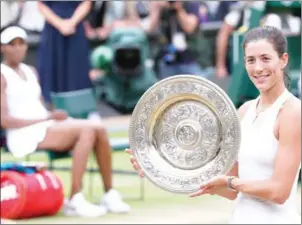  ?? AFP ?? Garbine Muguruza holds the Venus Rosewater Dish after beating Venus Williams to win the Wimbledon women’s singles final at Saturday.